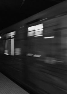 black and white photograph of a train speeding by