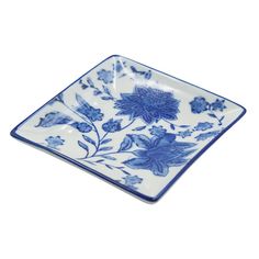 a blue and white square plate with flowers on it's side, against a white background