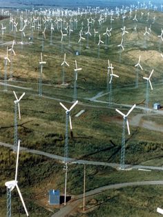 an aerial view of many wind turbines in a field