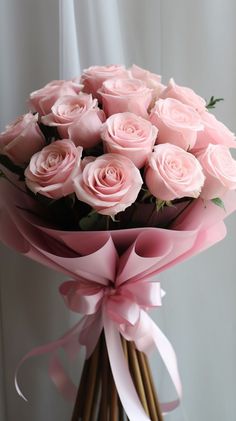 a bouquet of pink roses wrapped in ribbon