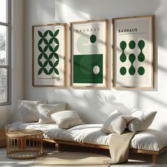 three green and white posters hanging on the wall above a couch in a living room