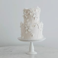 a three tiered cake with white flowers on it