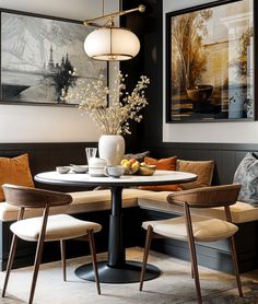 a dining room table with two chairs and a bench in front of it, along with pictures on the wall