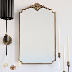 a mirror and some candles on a wall