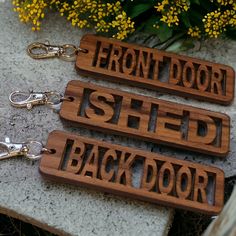 three wooden key chains with the words front door, shed and back door on them