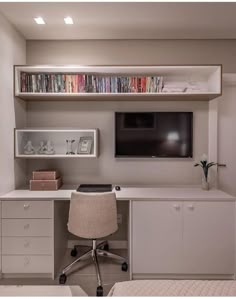 a room with a desk, chair and television on the wall above it is also a bed