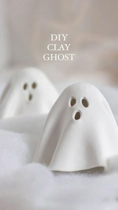 two white ghost figurines sitting on top of a bed with the caption diy clay ghost