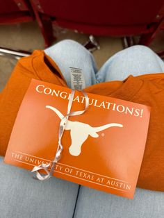 an orange book tied to the back of a person's chair with longhorns on it