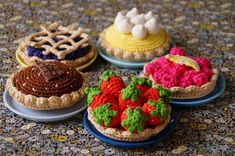 four crocheted pastries sitting on top of each other in different colors and designs