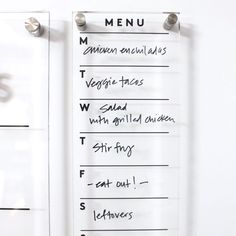 a menu hanging on the side of a white wall next to a drawer with drawers