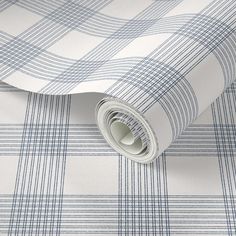 a blue and white plaid wallpaper with a rolled up roll on the floor next to it