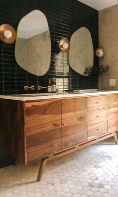 a bathroom vanity with two mirrors above it