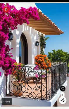 the balcony is decorated with flowers and wrought iron railing