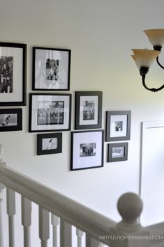 black and white photos hang on the wall above a banister