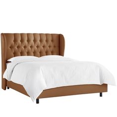 a bed with white sheets and a brown headboard on top of it's foot board