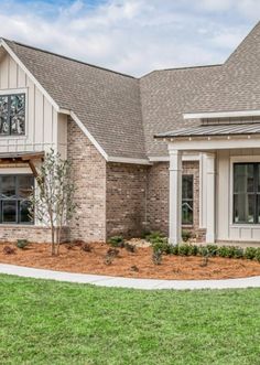 the front of a house with landscaping in front of it and grass on the ground