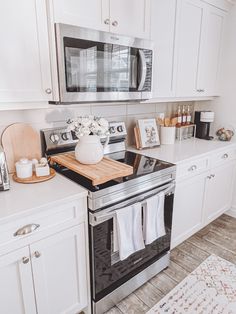 a kitchen with white cabinets and stainless steel appliances, including an oven, dishwasher, microwave and counter space