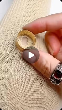 someone is holding an open ring on top of a couch with the video below it