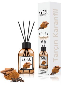 an open bottle of eyel with cinnamon sticks next to it and the box behind it