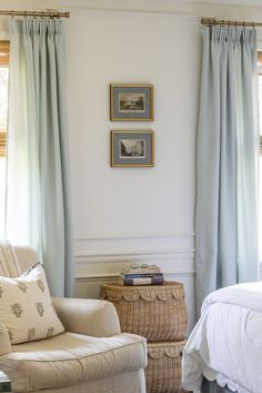 a bedroom with white walls and blue curtains