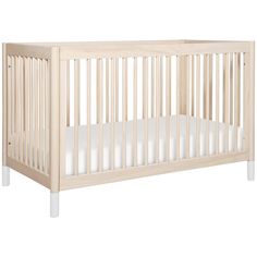 a wooden crib with white sheets on the bottom and sides, against a white background