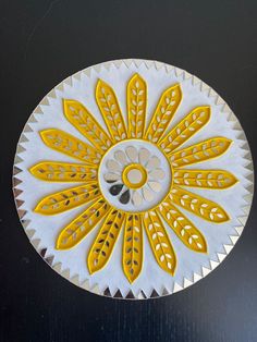 a yellow and white decorative object on a black surface