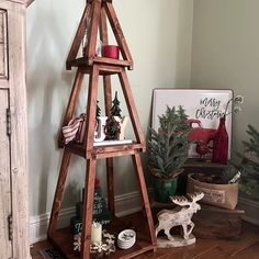 a christmas tree made out of wood stands on a wooden floor next to other decorations