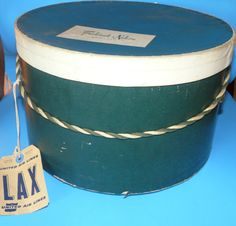 a green and white hat with a tag hanging from it's side on a blue surface