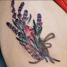 a woman's stomach with lavenders and a diamond tattoo on her side,