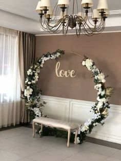 a white bench sitting under a chandelier next to a love sign