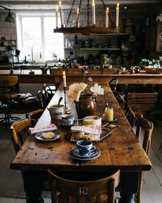 a wooden table topped with plates and cups