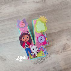 two children's toothbrushes with cartoon characters on them sitting on a wooden surface