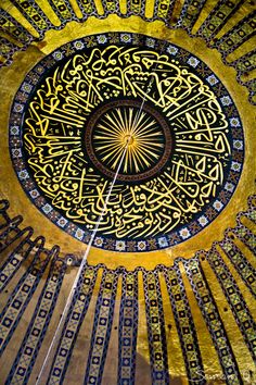 an intricate ceiling in the center of a building with gold and blue designs on it