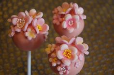 two pink cake pops with flowers on them