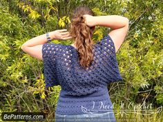 a woman with her back to the camera wearing a crochet top in front of trees