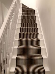 the stairs are lined with black and white striped carpet