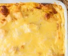 a casserole dish with cheese and meat in it sitting on a table top