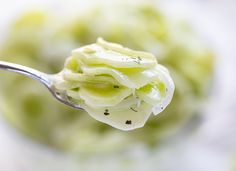 a close up of a spoon with some food on it's side and green stuff in the middle