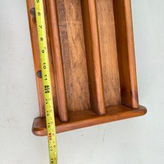 a wooden shelf with a measuring tape on it