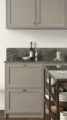 a kitchen with gray cabinets and marble counter tops