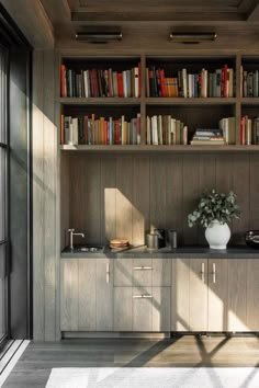 a bookshelf filled with lots of books next to a window