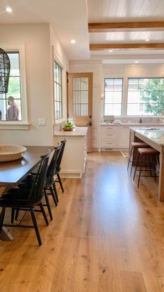 a dining room table and chairs in a kitchen with wood flooring on the side