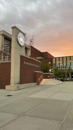 a large building with a clock on the side of it's face and stairs leading up to it