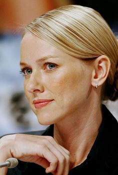 a close up of a person sitting at a table with a microphone in front of her