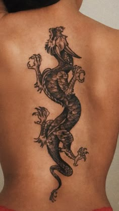 a woman's back with a tattoo on her body and an image of a dragon