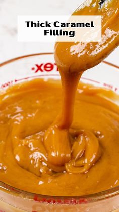 a spoon full of caramel sauce in a glass bowl with the words thick caramel filling