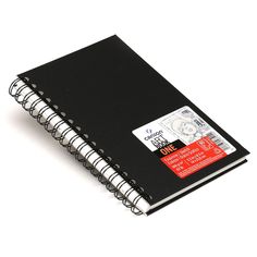 a black spiral notebook with red and white stickers on the front, sitting open