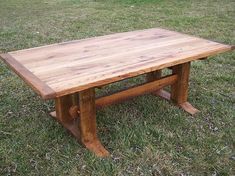 a wooden table sitting on top of a lush green field