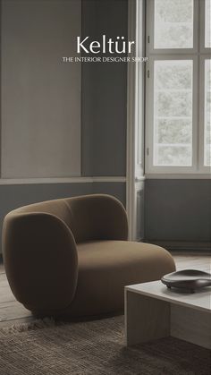 a living room with a chair and coffee table in front of a window that reads keltur the interior designer collection