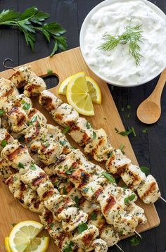 grilled chicken skewers on a cutting board with lemon wedges